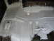 1973 Ford Ranchero - Undercarriage of a vehicle after undercoating application, revealing structural details.