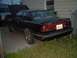 1989 Mazda MX-6 - A black 1989 Mazda MX-6 coupe is parked outside with its hood up, next to another vehicle and a fence.