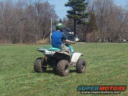 Person on 1994 Polaris TRAIL BOSS 325 riding in a grassy field