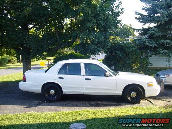White 2002 Ford Crown Victoria sedan parked on driveway, side view