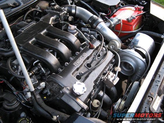 Mazda engine with turbocharger, intercooler piping, and red battery
