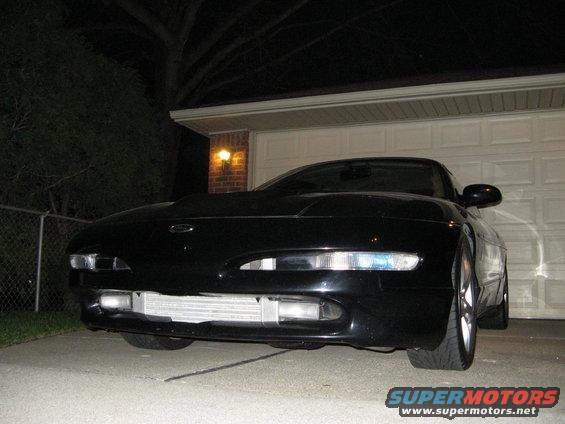 Black car front end with exposed intercooler and aftermarket headlights