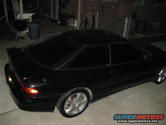 black coupe parked outside a brick building at night