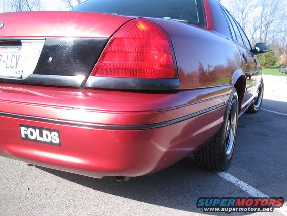 2001 Ford Crown Victoria rear quarter panel and taillight, with a 'FOLDS' sticker on the bumper