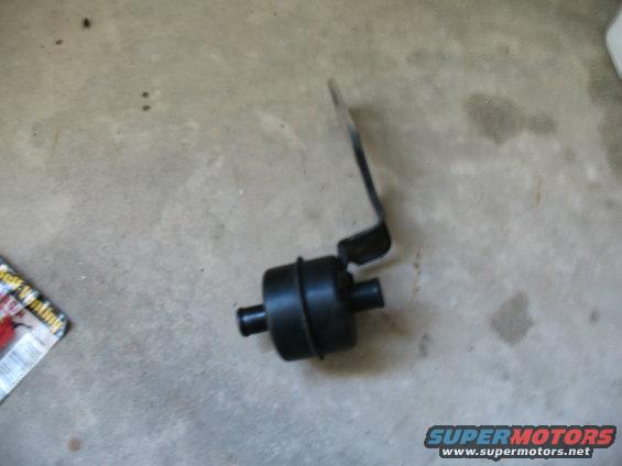 Black automotive part with metal bracket on concrete floor