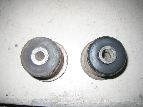 Two rubber and metal suspension bushings, one looks worn