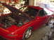 1994 Ford Probe - A red 1994 Ford Probe is shown with its hood open, revealing the engine bay, in what appears to be a garage setting.
