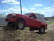 2001 Mazda B3000 - A red 2001 Mazda B3000 pickup truck is shown navigating a dirt terrain with its front wheels elevated.