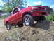 2001 Mazda B3000 - A red 2001 Mazda B3000 pickup truck navigates a challenging dirt obstacle.