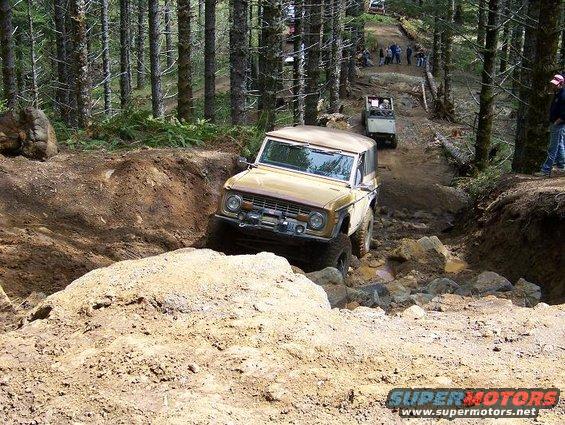 Tan 1968 Ford Bronco navigating a rocky off-road trail