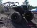 1989 Ford Bronco - This heavily modified off-road vehicle navigates a dirt mound, kicking up dust.