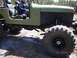 1989 Ford Bronco - This modified off-road vehicle is seen from the side with a driver inside.
