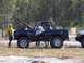 1989 Ford Bronco - A black 1989 Ford Bronco is seen with its hood open and a roll cage installed, parked outdoors.