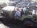 1989 Ford Bronco - Two people in an off-road vehicle struggle through deep mud.