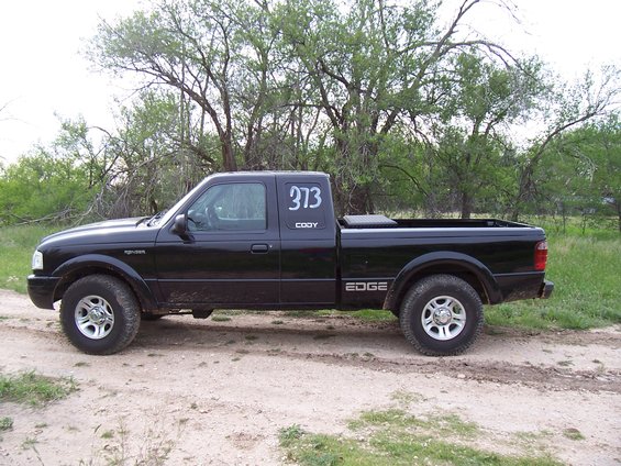 Black 2003 Ford Ranger pickup truck, side view, with "373 CODY" on the door