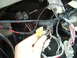 1978 Ford Bronco - Close-up of a vehicle's interior wiring harness with a hand holding a connector.