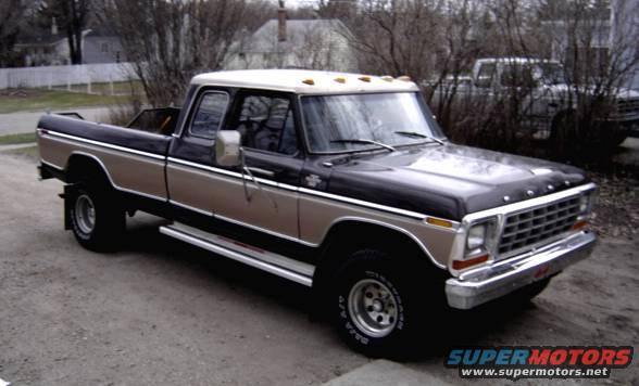 Two-tone pickup truck, front quarter view. Another truck is visible in the background