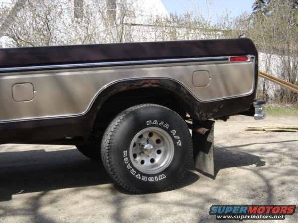 Side view of a 1970s pickup truck's rear wheel and quarter panel
