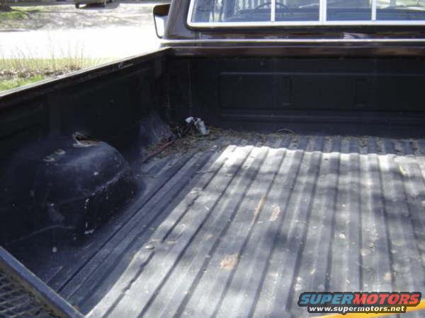 Truck bed interior with ribbed floor, dark color, and visible wheel well