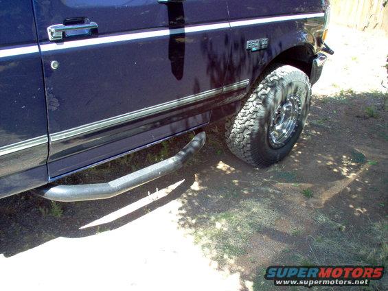 Side view of a dark blue 1995 Ford Bronco with chrome trim and running boards