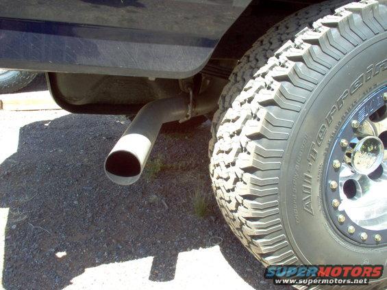 Exhaust pipe and off-road tire on a dark blue vehicle