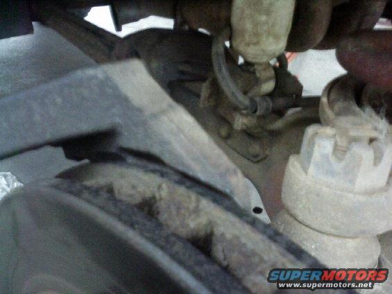Close-up of rusty suspension parts and a lug nut on a vehicle