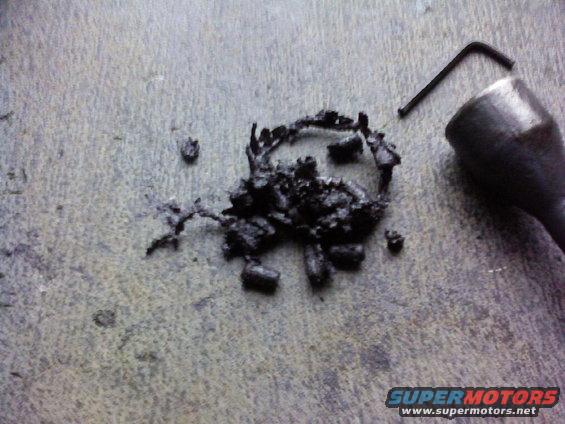 Burnt debris and a hex wrench on a textured surface