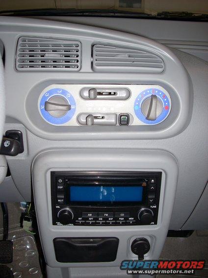 Car dashboard with gray plastic, air vents, radio, and climate controls