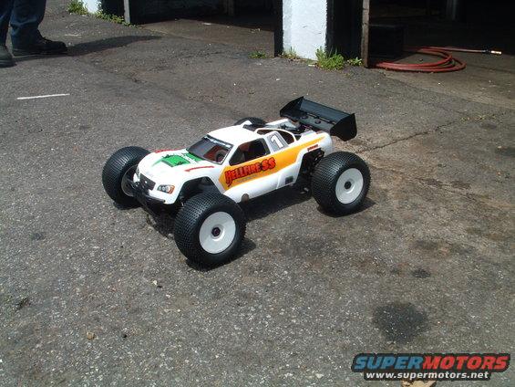 White remote control monster truck with orange and green graphics, labeled 'HELLFIRE SS'