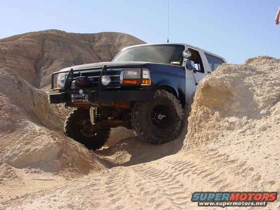 1994 Ford Bronco navigating sandy terrain, front winch and bull bar visible