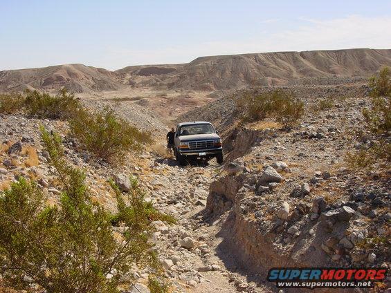 Gray pickup truck on rocky desert trail, 1994 model year suggested by grille