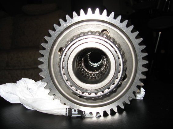 close-up of a metal gear with a bearing assembly inside, resting on white paper