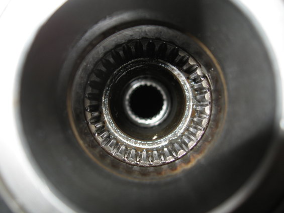 Close-up of a splined shaft hub with a dark central opening and metallic teeth