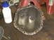 2005 Ford Excursion - Differential cover on a workbench with a water bottle and jack stands in the background.