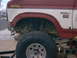 1986 Ford Bronco - Close-up of the front fender and wheel well of a lifted 1986 Ford Bronco.