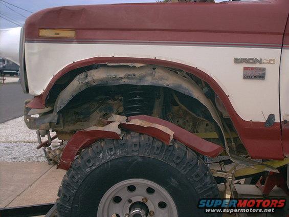 Red and white 1986 Ford Bronco fender and wheel with visible 'BRONCO' and 'OVERDRIVE' badges