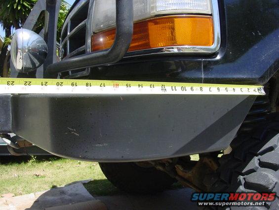Black Ford Bronco front bumper with a tape measure across it, showing a measurement of 12 inches