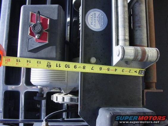 Measuring tape on vehicle bumper part with 'Mall Rated' sticker