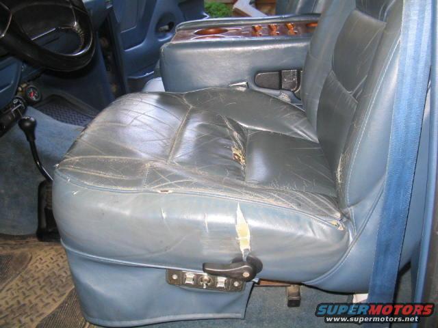 Worn blue leather interior with manual shifter and cracked seats