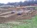 2001 Dodge 1500 - Two trucks navigate a challenging mud race course, with onlookers gathered to watch the competition.