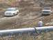 2001 Dodge 1500 - Two pickup trucks navigate a muddy off-road course during an event.