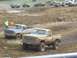 2001 Dodge 1500 - Two pickup trucks compete in a mud race event, with one truck prominently displaying racing decals.