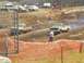 2001 Dodge 1500 - Two pickup trucks compete in a mud race event, with spectators and other vehicles visible in the background.