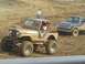 2001 Dodge 1500 - Two modified off-road vehicles, a Jeep and a Dodge pickup, compete on a dirt track.