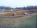 2001 Dodge 1500 - Off-road vehicles compete in a mud bogging event on a dirt track with spectators in the background.