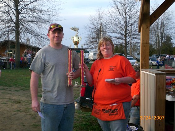 People holding a trophy at an outdoor event