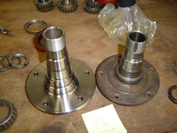 Two wheel hubs with bearings and seals on a wooden surface