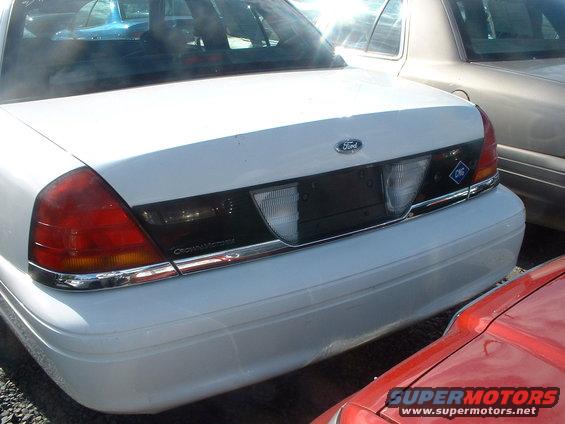 White Ford Crown Victoria rear end with a 'CNG' sticker on the trunk lid. Another car is parked to the right