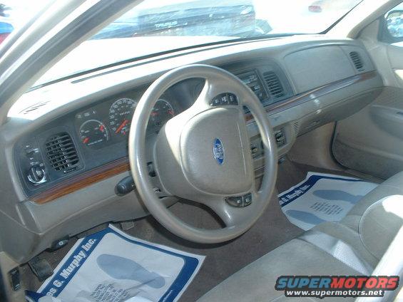 2000 Ford Crown Victoria interior showing dashboard, steering wheel with Ford logo, and floor mats