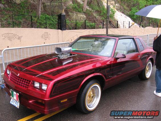 Red custom coupe with a hood scoop and wire wheels. License plate is from Mexico